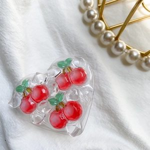 Detail of heart-shaped phone grip with 3D cherry and ice cubes on white fabric
