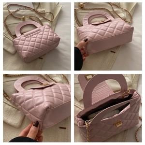 Detail view of pink quilted handbag showing gold chain strap and interior storage