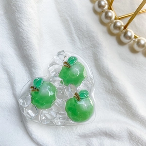 Macro detail of a heart-shaped resin phone socket with green apples and ice cubes