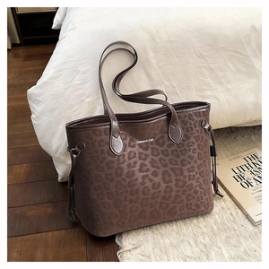 Detail of leopard print tote bag featuring Creative Cat text and side drawstring texture