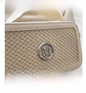 Detail of beige leather box bag featuring woven texture and round metal M logo