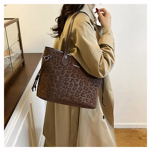 Detail of leopard print tote bag with Creative Cat text and slim brown shoulder straps
