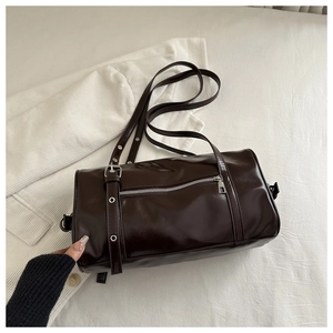 Detail of dark brown vintage Boston barrel bag with silver zippers and buckle accents