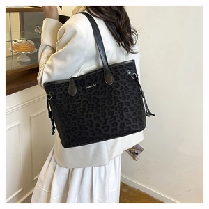 Detail of leopard print tote bag featuring a metal logo and stylish drawstring design