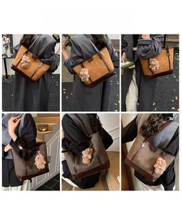 Detail shots of large suede tote bag with leather trim and plush bear charm accessory