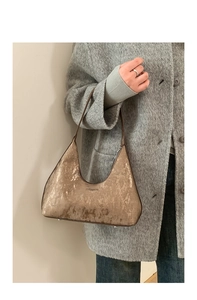 Dettaglio borsa a spalla bronzo metallizzato con trama verticale e tracolla fine