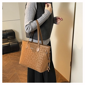 Close-up of leopard print tote bag with Creative Cat text and side drawstring detail