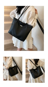 Vue lifestyle d'un sac cabas noir en cuir grainé porté à l'épaule dans un escalier