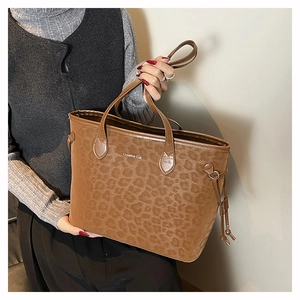 Close-up of leopard print tote bag featuring Creative Cat text and metal drawstring detail