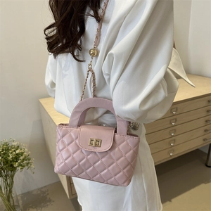 Pink quilted crossbody bag with gold chain strap and turn-lock on a model