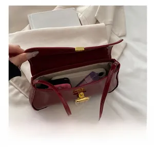 Detail showing the internal storage capacity of the wine red patent leather shoulder bag