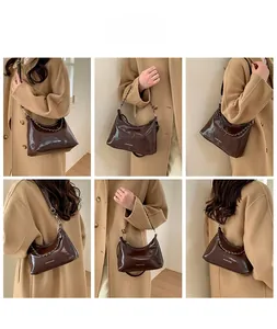 Detail of dark brown glossy leather tote featuring silver chain and white fashion text