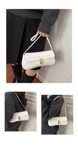 Detail of white PU leather underarm bag with gold chain buckle and slender shoulder strap
