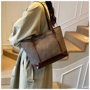 Detail of the suede tote bag showing Hello Kitty embossed patterns and brown leather strap