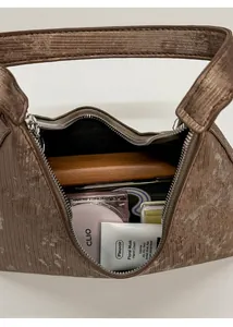 Macro view of brown textured velvet handbag showing internal space for daily cosmetics