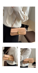 Detail of pale pink patent leather baguette bag with golden oval lock and slim strap