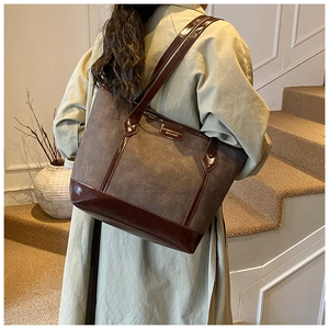 Detail of vintage tote bag featuring embossed cat patterns and polished leather handles