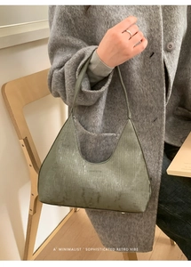 Dettaglio della borsa hobo verde scuro con pelle a trama verticale e tracolla regolabile