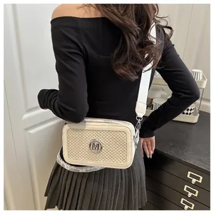 Dettaglio borsa a tracolla beige con trama intrecciata, logo M argento e tracolla in tessuto
