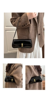 Detail of black patent leather underarm bag with gold buckle on a brown blazer model