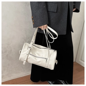 Detail of a minimalist off-white pillow bag with metal hardware and leather texture