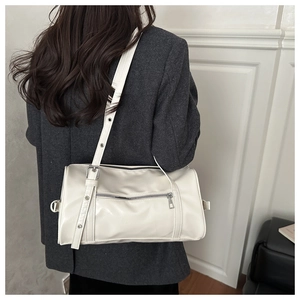Detail of cream white PU leather Boston bag showing adjustable silver eyelet strap
