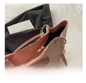 Dettaglio ravvicinato della cerniera e dell'etichetta logo della borsa beige tote