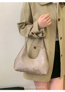 Dettaglio della borsa tote beige minimalista che mostra la trama e il logo inciso