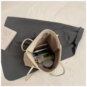 Close-up of beige lychee grain tote bag interior showing spacious storage for cosmetics