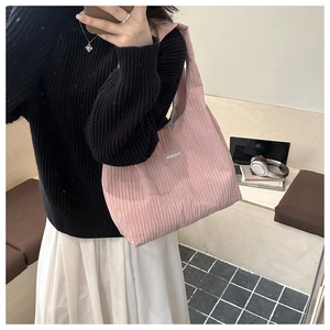 Detail of pink pleated tote bag fabric texture with fashion logo label and vertical folds