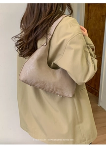 Vista posteriore della borsa tote retrò minimalista indossata con un trench beige classico