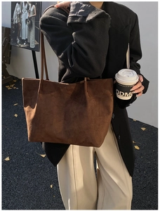 Dettaglio della borsa tote in pelle scamosciata marrone scuro con outfit autunnale