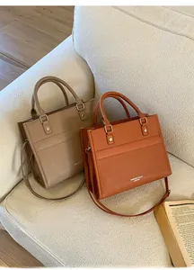 Dettaglio di borse tote in pelle albicocca e caramello su un divano in tweed