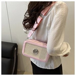Pink shoulder bag featuring beige woven texture and silver M logo shown on a model