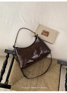 Brown vintage hobo bag with chain strap and brand logo on a stylish chair detail