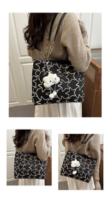 Detail of star-patterned tote bag with gold chain strap and cute cloud charm accessory