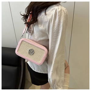 Detail of pink PU leather crossbody bag featuring beige woven panel and M-letter metal buckle