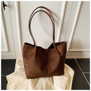 Detail of minimalist dark brown suede tote bag with slim shoulder straps for daily use