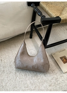 Detail of vintage brown shoulder bag with distressed silver coating on soft carpet