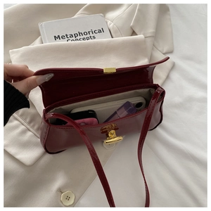 Top view of burgundy patent leather bag showing interior capacity and golden lock