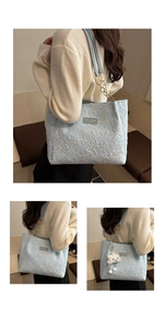 Detail of light blue tote bag with star embroidery, chain strap and cloud charm