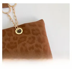 Close-up of leopard print fabric texture and gold metal chain hardware detail