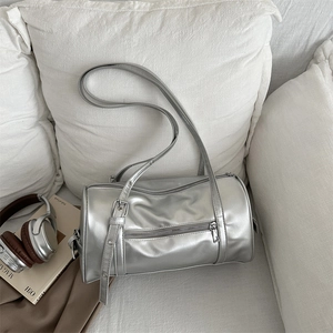 Minimalist silver matte leather cylinder crossbody bag with adjustable strap and side pocket