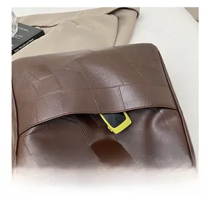 Close-up of the stylish side pocket on this dark brown woven leather tote bag