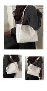 Close-up of white tote bag with ruffled floral texture and metallic chain strap