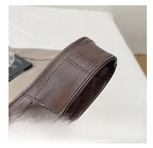 Detailed view of dark brown embossed crocodile leather shoulder strap with neat stitching