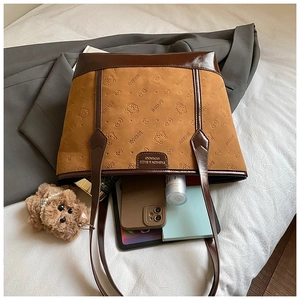 Detailed view of spacious brown tote bag with cat patterns and daily essentials inside
