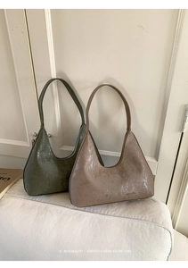 Detailed view of textured shoulder bags with metallic finish and vertical striped pattern