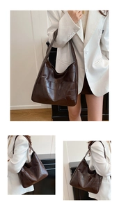 Detail of a deep brown patchwork leather tote bag with geometric textured panels
