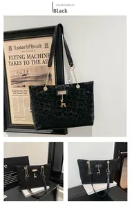 Detail of dark gray leopard print tote bag with gold chain strap and deer pendant charm